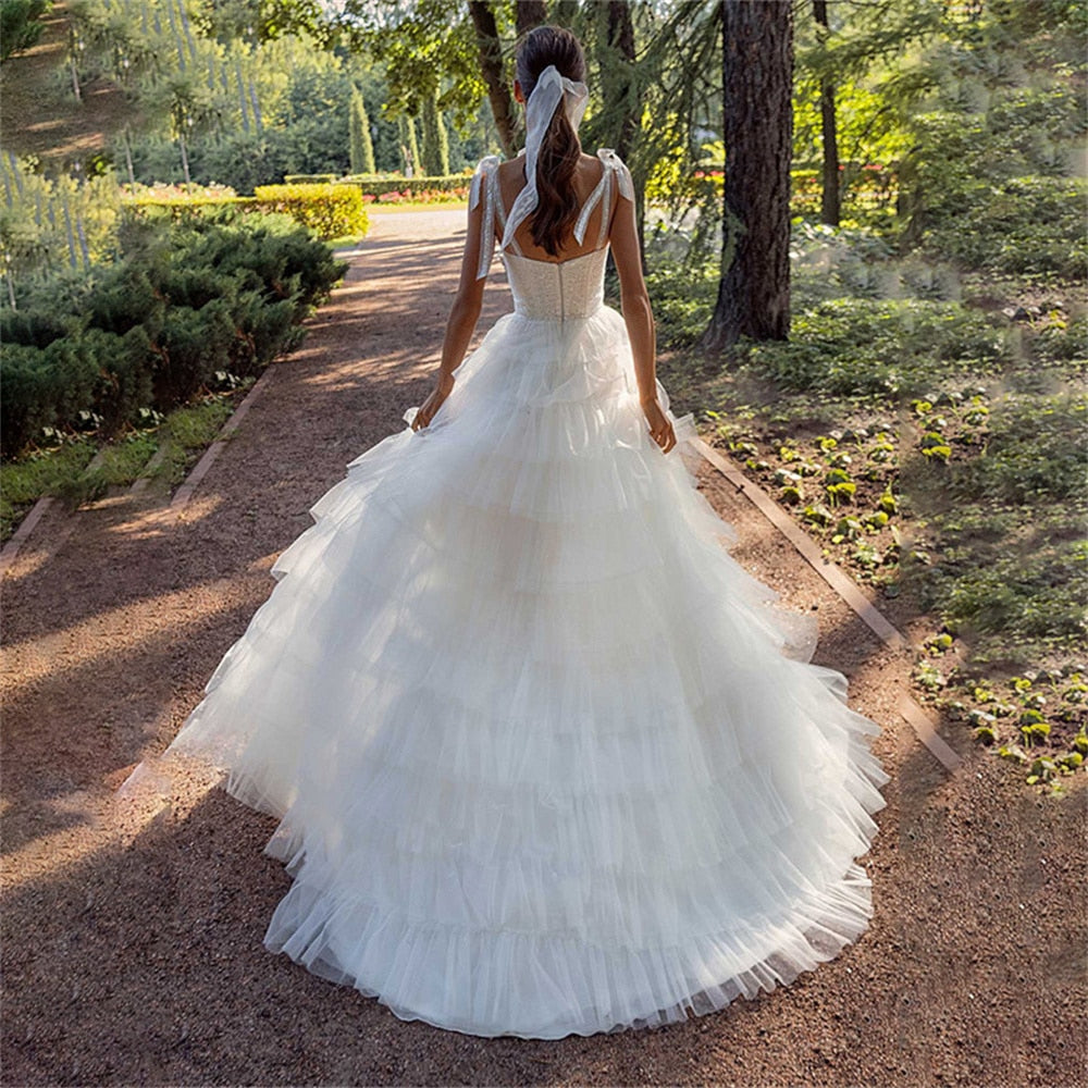 Indulge in pure luxury with our elegant Robe Fena. This sexy bohemian wedding dress features delicate tiered straps and a stunning open back. Its A-line silhouette will flatter your figure while allowing you to move gracefully on your special day. Say "I do" in style with Robe Fena.